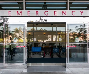 "Entrance to hospital emergency department with wheelchairs inside."
