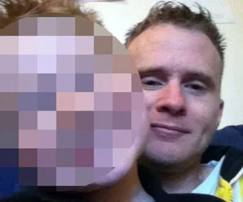 A man is seen smiling with another person's face pixelated beside him.