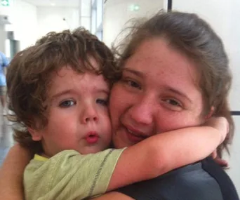 A mother and child hugging tightly with emotional expressions.