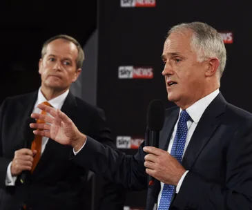 Two men in suits holding microphones, engaged in a debate, with a Sky News backdrop.