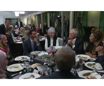Guests seated around a table during a Ramadan dinner, engaging in conversation and enjoying the meal.