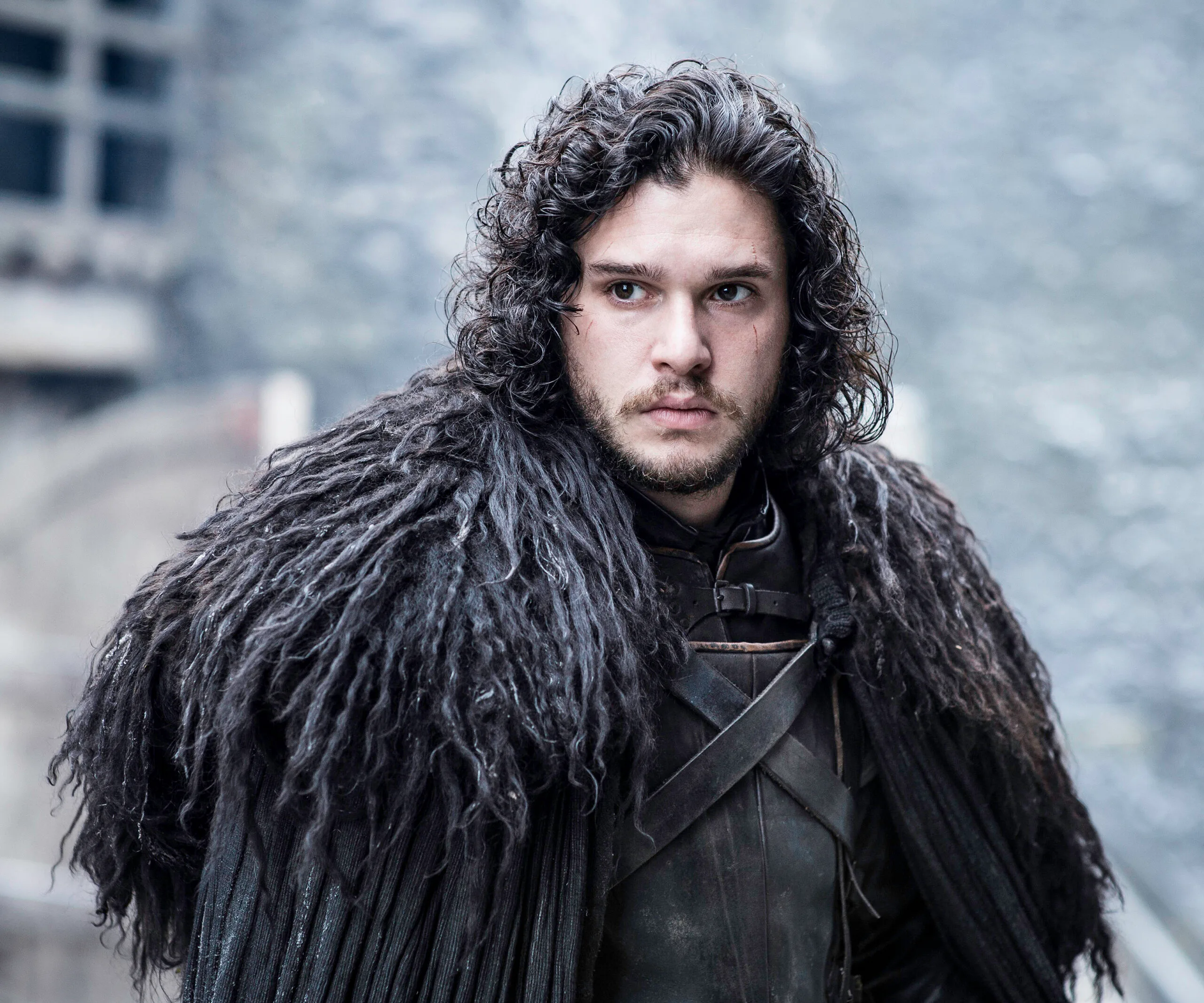 Jon Snow in dark fur cloak looks focused in a scene from Game of Thrones Season 6.