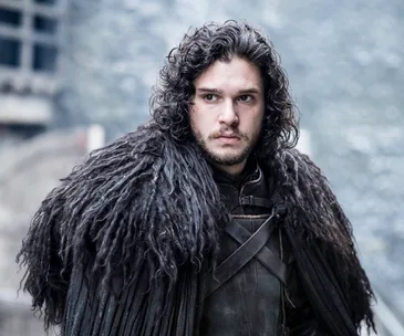 Jon Snow in dark fur cloak looks focused in a scene from Game of Thrones Season 6.