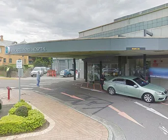 Newcastle Private Hospital entrance with a car parked outside under an overcast sky.
