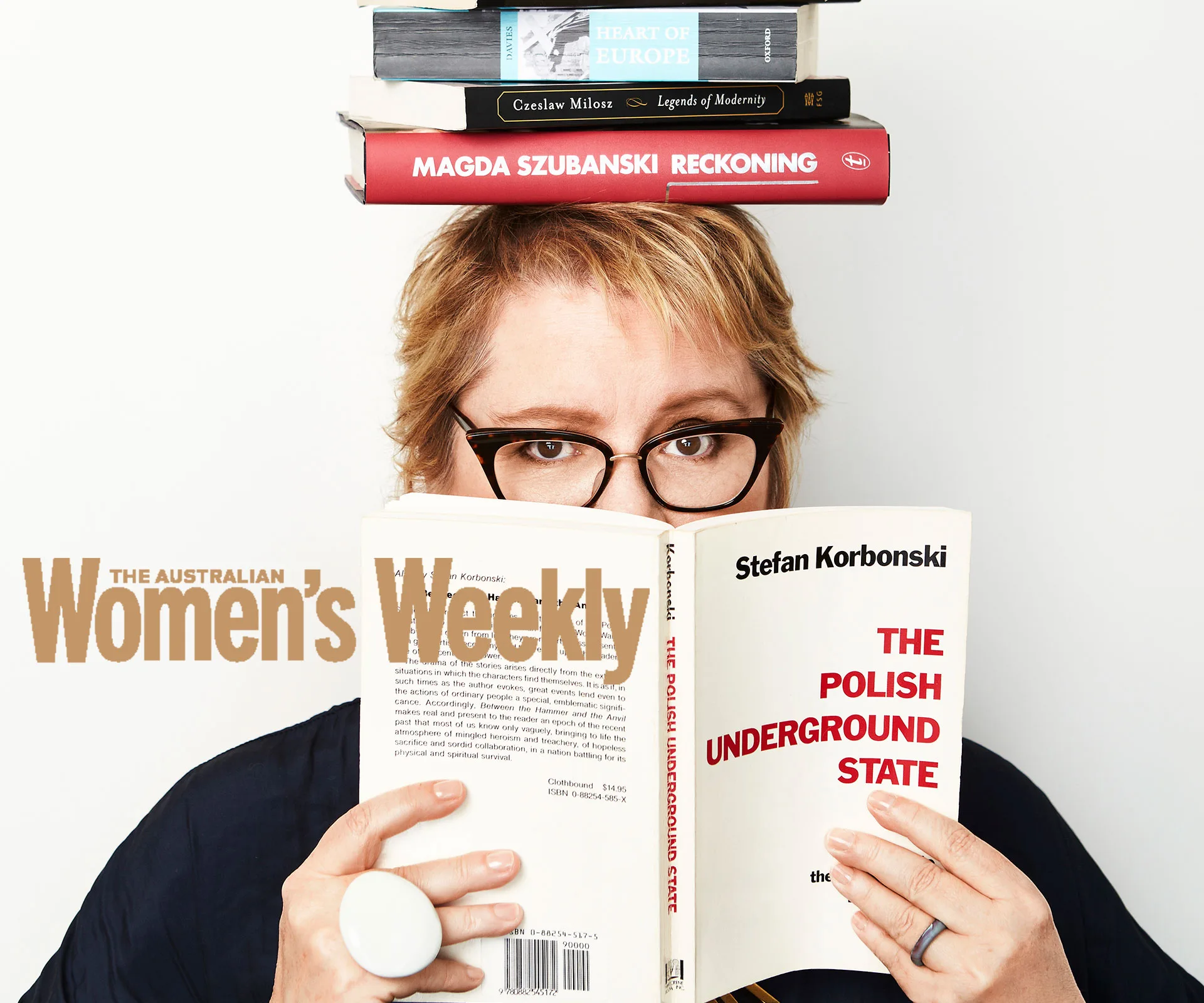 Person balancing books on their head, reading a book titled "The Polish Underground State" on cover of The Australian Women's Weekly.