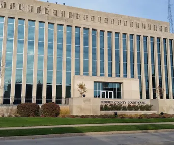 Berrien County Courthouse front with large windows and a sign on a sunny day.