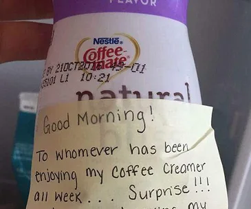Hand holding coffee creamer bottle with note warning fridge thief about breast milk swap as revenge.
