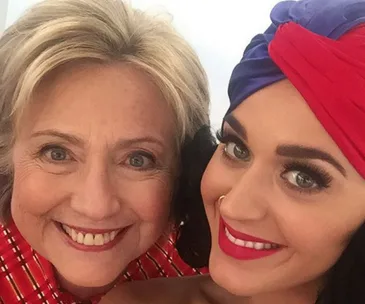 Two women smiling for a selfie, one with a red and blue headwrap.
