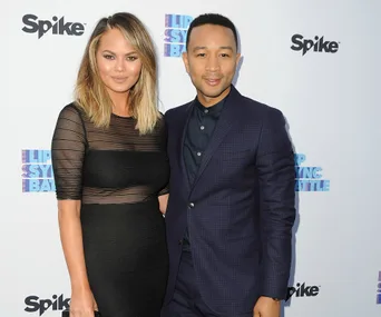 A couple poses on the red carpet at the Lip Sync Battle event, both dressed elegantly, with branded backdrop in view.