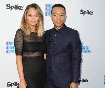 A couple poses on the red carpet at the Lip Sync Battle event, both dressed elegantly, with branded backdrop in view.