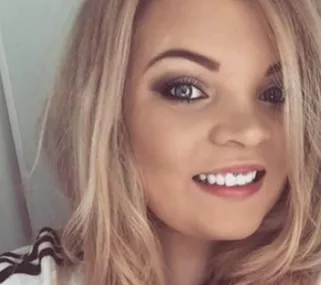 Close-up selfie of a young woman with blonde hair and bright smile.