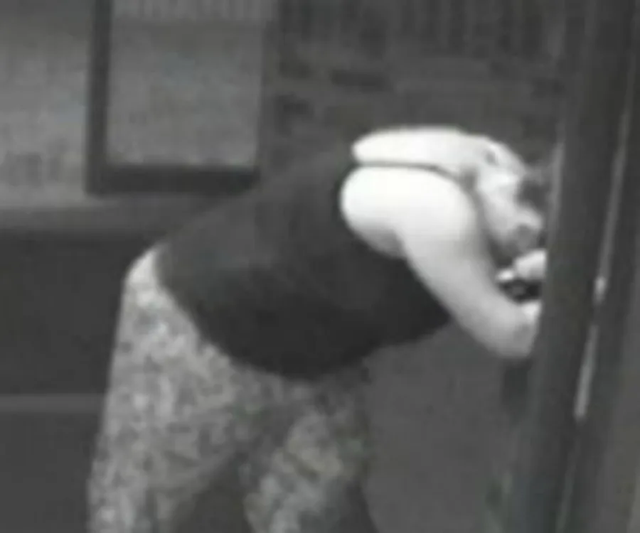 A woman in labor leans against a wall in a grainy surveillance image, captured moments before giving birth quickly.