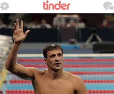 Swimming athlete waving in pool with visible Olympic rings tattoo, under Tinder app header.