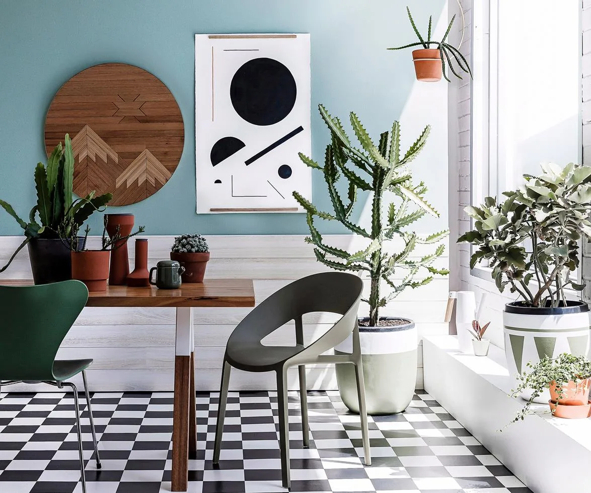 Indoor space with various potted plants, modern furniture, and abstract wall art.