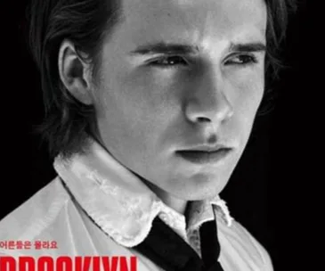 Black and white portrait of a person in a collared shirt and tie, featured on a magazine cover.