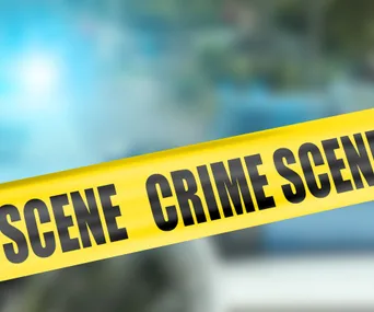 Yellow crime scene tape against a blurred background.