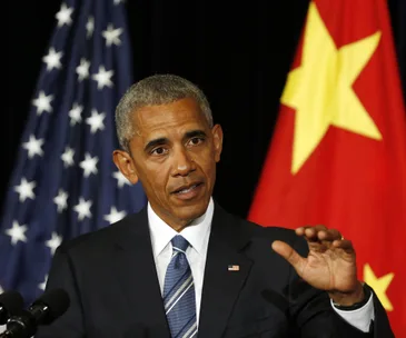 A man in a suit speaks at a podium, with U.S. and China flags in the background.