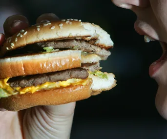 Person about to eat a double cheeseburger.