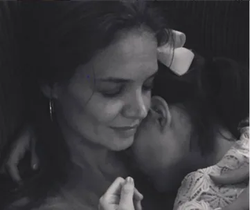 A woman and child share a tender embrace, the child rests her head on the woman's chest.