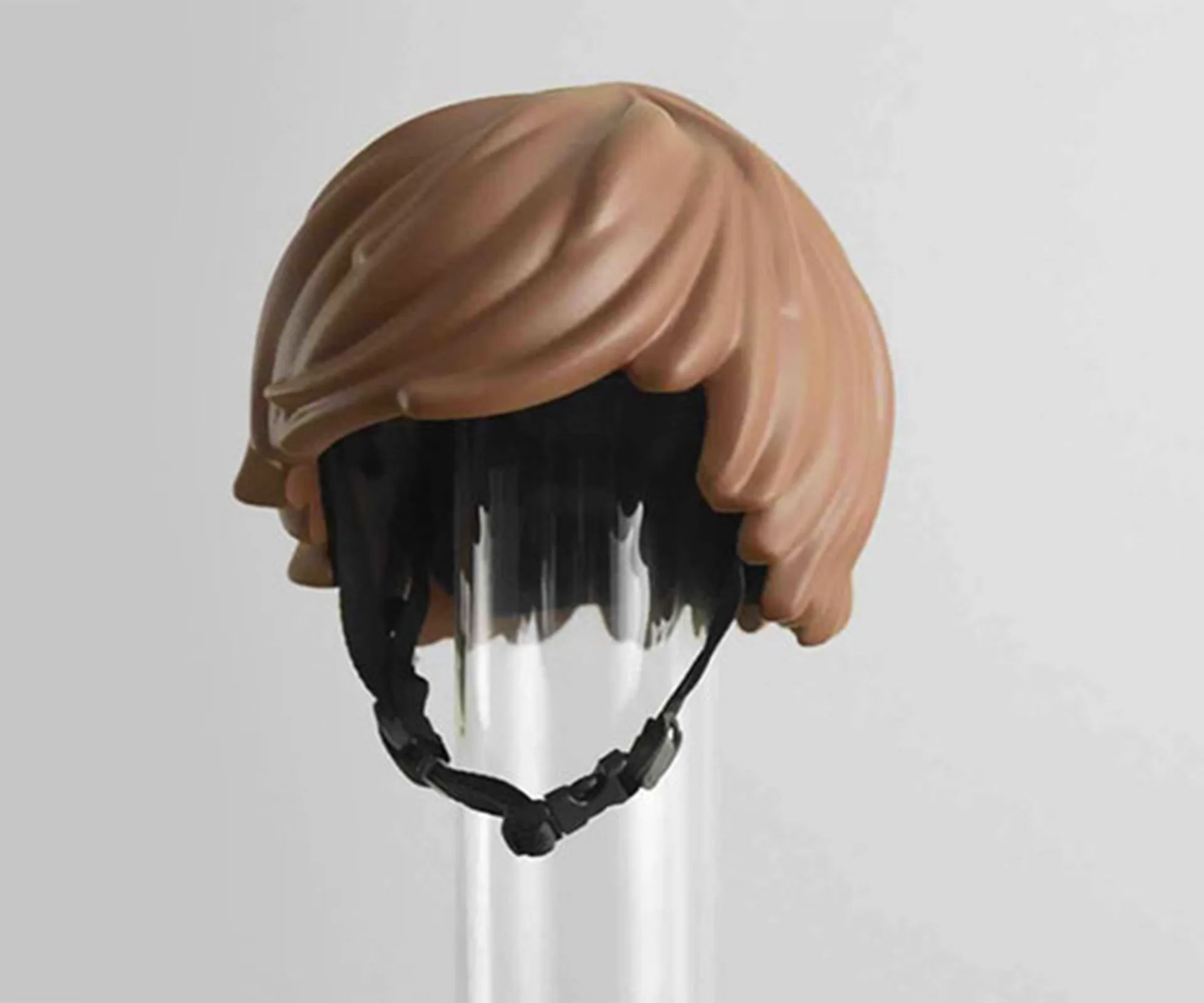 Brown Lego-style bike helmet shaped like hair, placed on a clear stand.