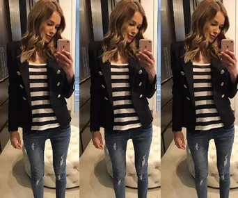 A woman takes a mirror selfie, wearing a black blazer, striped shirt, and jeans, with her reflection visible thrice.