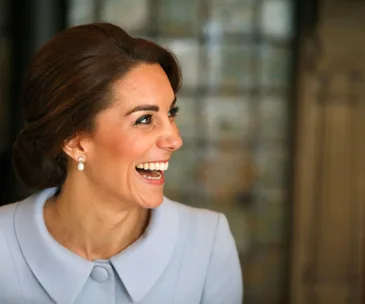 The Duchess of Cambridge smiling, wearing pearl earrings during a visit to the Netherlands.