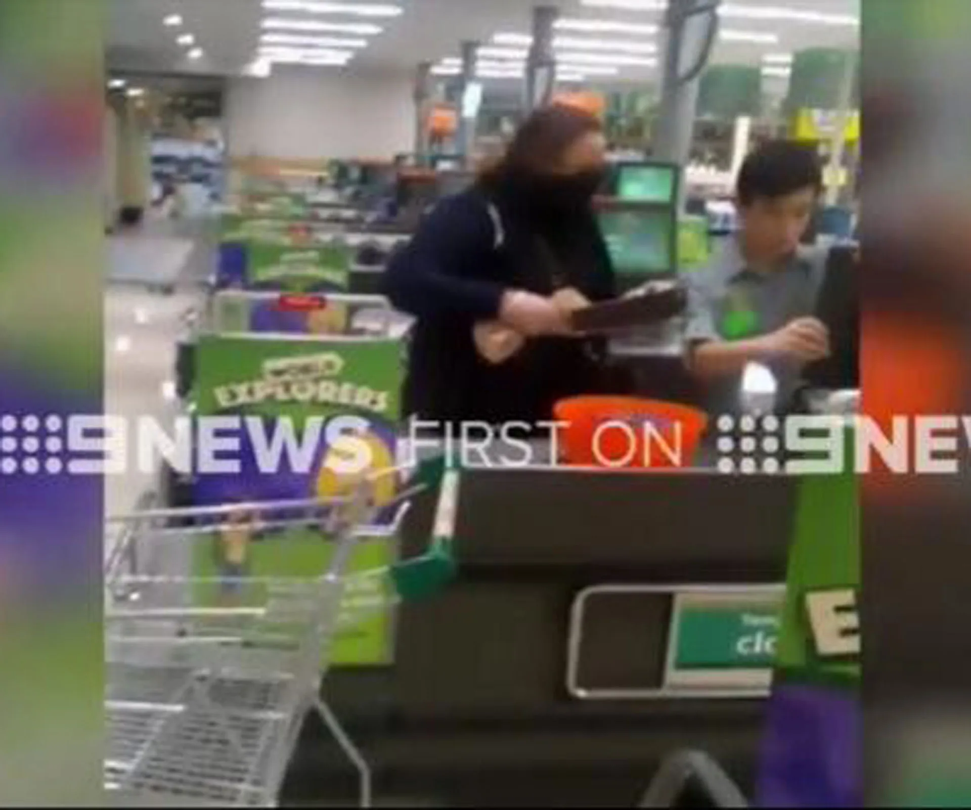 A masked woman wielding a machete at a supermarket checkout counter, captured by 9NEWS.