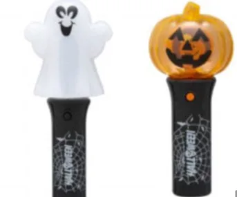 Two Halloween toy lamps: one with a smiling ghost, the other with a pumpkin face, on black handles with spider webs.