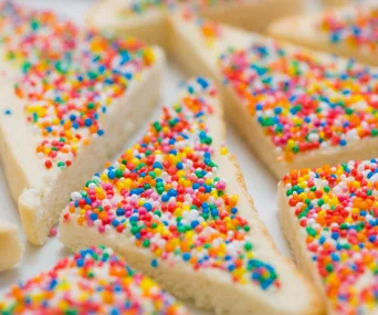 Slices of white bread topped with colorful sprinkles, known as fairy bread, a popular Australian treat.