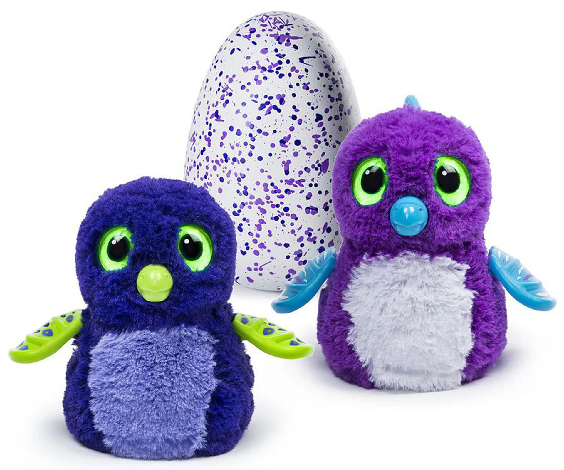 Two colorful Hatchimal toys with big eyes next to a speckled egg.