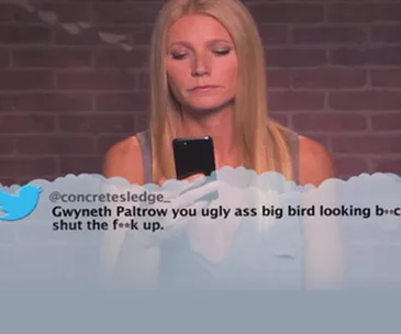 A woman reading a mean tweet directed at her from a mobile phone, highlighting online abuse issues.