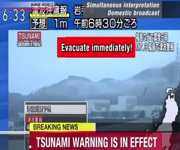 "Screenshot of NHK broadcast with tsunami warning in effect after massive earthquake, urging immediate evacuation in Japan."