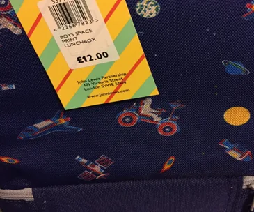 "Space-themed lunchbox with astronaut motifs and a price tag from John Lewis for £12.00."