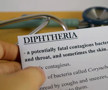 "Document with 'Diphtheria' heading, text detailing contagious disease, with part of a stethoscope visible in the background."