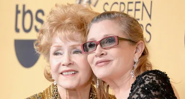 Two women smiling together at an awards event, with a yellow backdrop displaying "tbs" and "Screen Actors Guild".