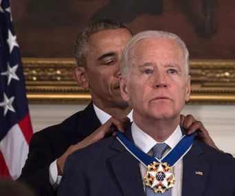 "Person receiving the Presidential Medal of Freedom, looking emotional during ceremony."