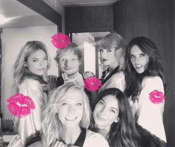 A group of smiling people posing for a photo. Pink lipstick marks are added to the image.