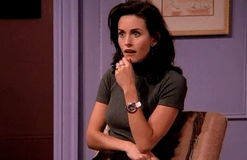 GIF of a surprised woman sitting on a chair, hand on chin, from a popular TV show.