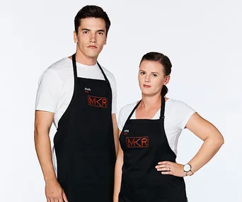 Josh and Amy from My Kitchen Rules, wearing black aprons with the MKR logo, standing against a plain white background.