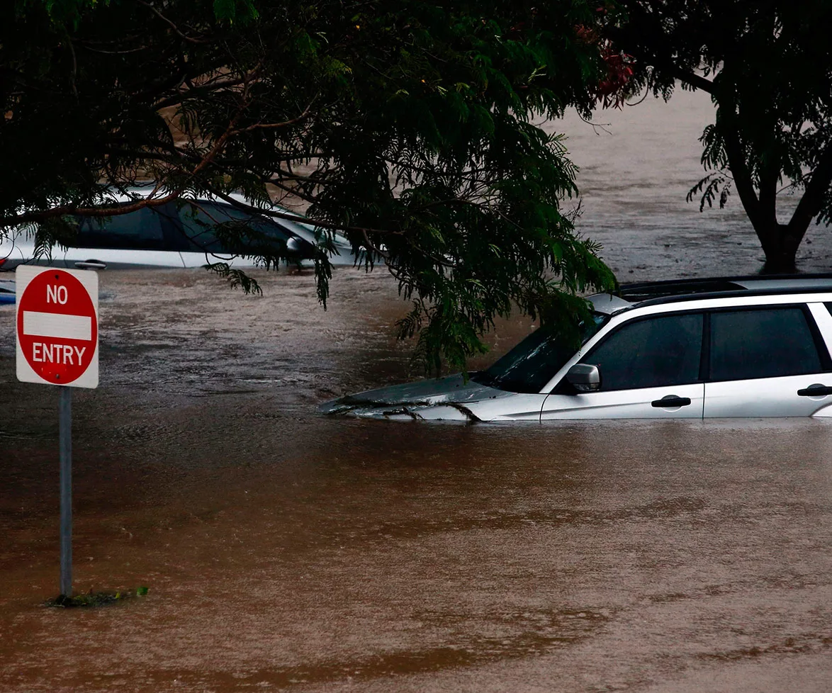 Flooded street with submerged cars and a "No Entry" sign during Cyclone Debbie in Moreton Bay, 2017.