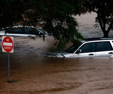 Flooded street with submerged cars and a "No Entry" sign during Cyclone Debbie in Moreton Bay, 2017.