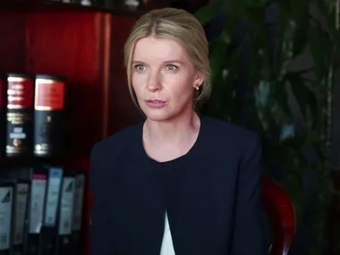 A woman in an office setting with books and files in the background, from the movie "Don't Tell" (2017).