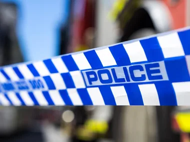 Police tape with blue and white checkered pattern, blurred background.