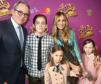 Family at "Charlie and the Chocolate Factory" theater event, posing together on a purple carpet.
