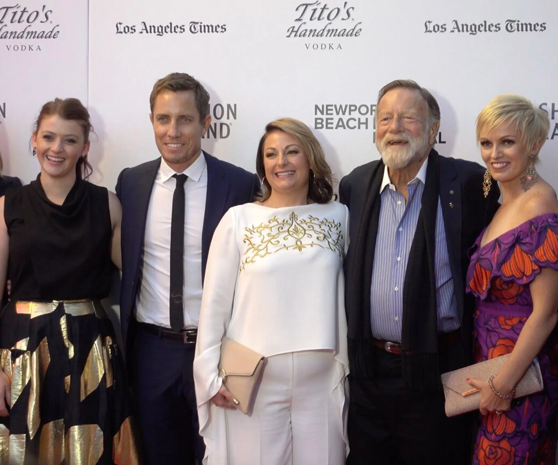 Group of five people posed smiling on the red carpet at the "Don't Tell" premiere event.