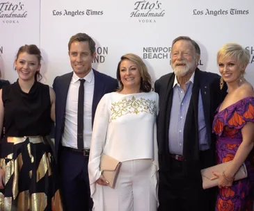 Group of five people posed smiling on the red carpet at the "Don't Tell" premiere event.