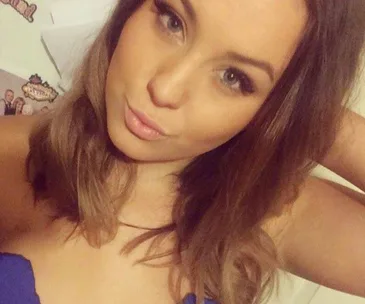 Young woman taking a selfie, looking at the camera with a neutral expression.