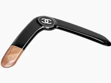 Black Chanel boomerang with logo, featuring a wood accent on one end.