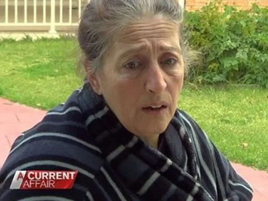 Woman in a striped robe outdoors, portrayed on 'A Current Affair', with a concerned expression.