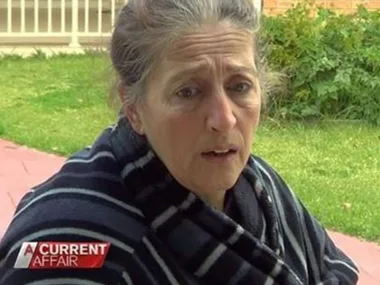 Woman in a striped robe outdoors, portrayed on 'A Current Affair', with a concerned expression.